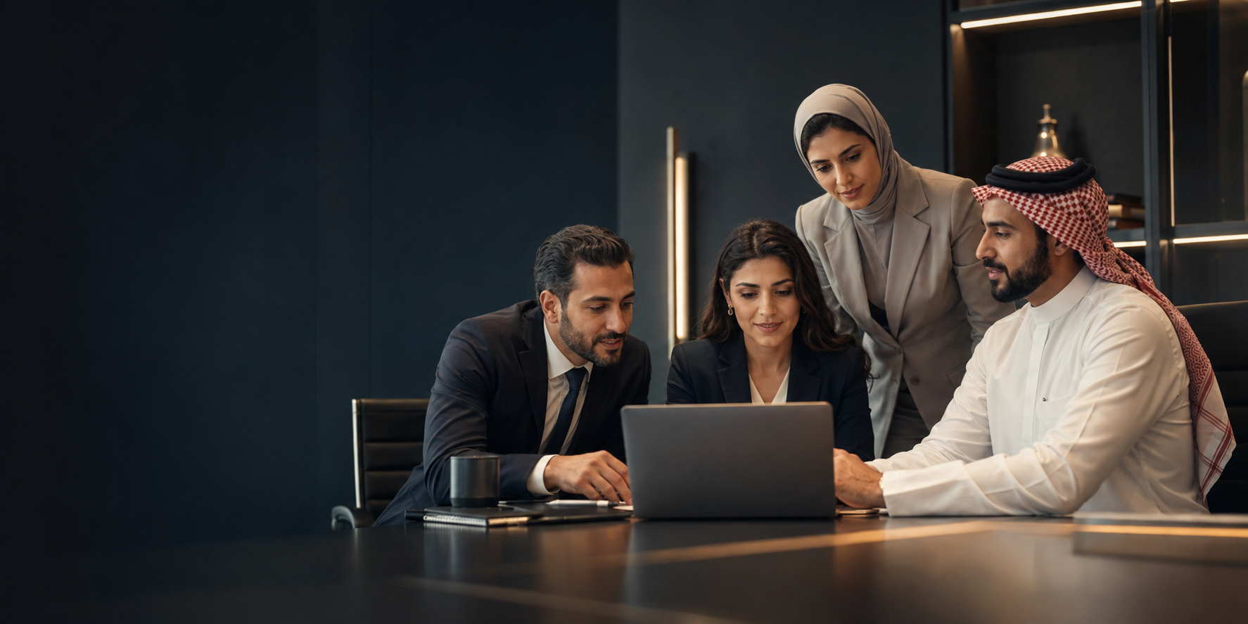 A diverse team of MENA consultants collaborating around a laptop